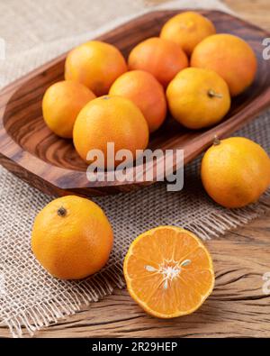 Cravo oder RosenZitronen in einer Schüssel über einem Holztisch. Stockfoto