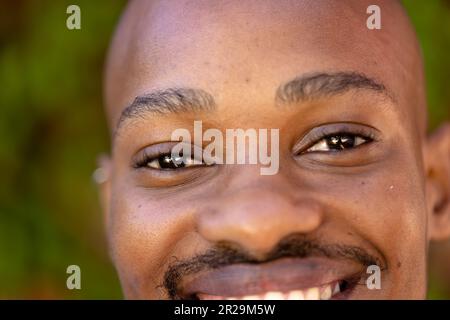 Nahaufnahme eines afroamerikanischen jungen Mannes mit schwarzen, lächelnden Augen Stockfoto