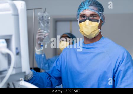 Das Porträt des weissen männlichen Chirurgen, der Operationsgeräte im Operationssaal vorbereitet Stockfoto