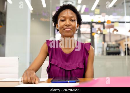 Porträt einer afroamerikanischen selbstbewussten Geschäftsfrau mit einem digitalen Tablet auf dem Schreibtisch im Büro Stockfoto