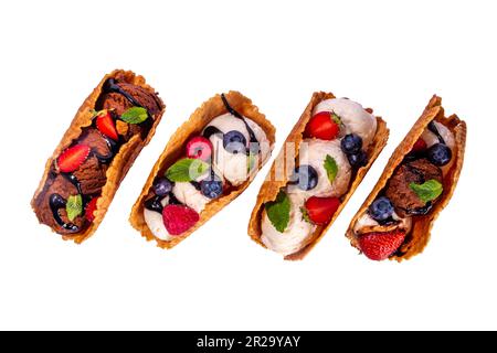 Verschiedene süße Taco-Eiscreme. Waffel-Taco-Muscheln mit Schokolade- und Vanillegeschmack, Eis mit verschiedenen Früchten, Beeren, Garnierungen, isoliert auf Whi Stockfoto