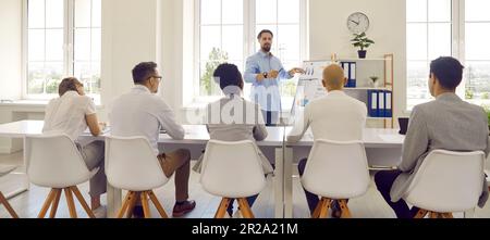 Der Couch Trainer des Mannes lehrt die Kommunikation mit einer Gruppe erwachsener Schüler, die flipboard mit Karten verwenden. Stockfoto