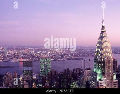 Chrysler Building beleuchteter Abendhimmel. United Nations Building Commercial Real Estate die Skyline von East River New York City von oben, Midtown USA Stockfoto