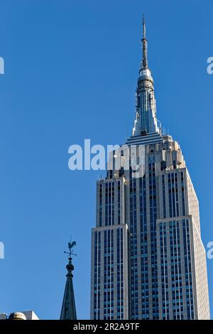 Entlang der Fifth Avenue werfen die Marble Collegiate Church (29. Straße) und das Empire State Building (34. Straße) ihre Türme in den frühen Morgenhimmel. Stockfoto