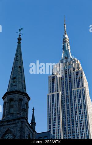 Entlang der Fifth Avenue werfen die Marble Collegiate Church (29. Straße) und das Empire State Building (34. Straße) ihre Türme in den frühen Morgenhimmel. Stockfoto