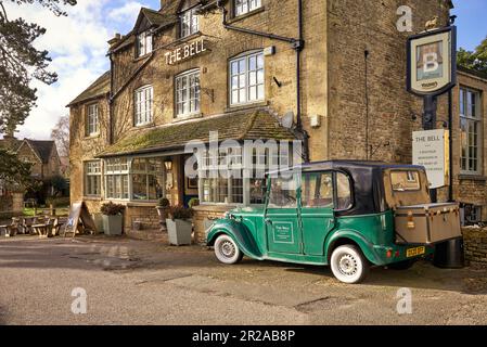Bell Hotel und Country Pub mit Suzhou Eagle EG6060K Elektroauto, das einem alten Rolls Royce ähnelt. Stau-on-the-Wold, Cotswolds, England Stockfoto