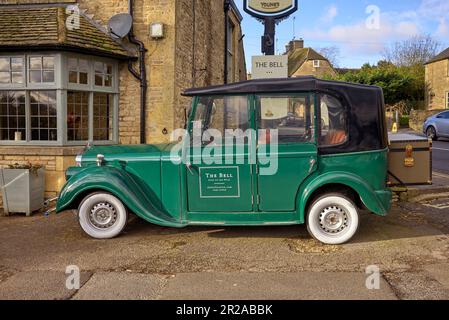 Bell Hotel und Country Pub mit Suzhou Eagle EG6060K Elektroauto, das einem alten Rolls Royce ähnelt. Stau-on-the-Wold, Cotswolds, England Stockfoto