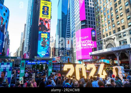 New York, USA. 18. Mai 2023. Die Leute sehen sich bei einer Launch-Veranstaltung am Times Square Plakate mit den offiziellen Logos für die FIFA-Weltmeisterschaft 2026 in New York/New Jersey an. Die Veranstaltung enthüllte die offiziellen Themen für die Spiele des MetLife Stadions: „We are NYNJ“ und „We are 26“. Der weltweit führende Fußballwettbewerb plant bereits 8 Spiele in der Gegend um New York/New Jersey, und die lokalen Veranstalter möchten auch hier das Finalspiel ausrichten. Kredit: Enrique Shore/Alamy Live News Stockfoto