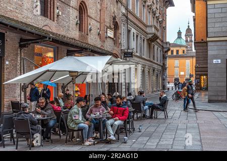 Touristen an den Tischen der Bar auf der Piazza del Monte unter dem Palazzo del Capitano del Popolo in Reggio Emilia. Reggio Emilia, Emilia Romagna, Italien Stockfoto