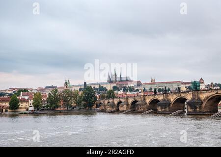 Die Prager Burg und der Veitsdom in der Abenddämmerung vom Ufer der Moldau aus gesehen. Stockfoto