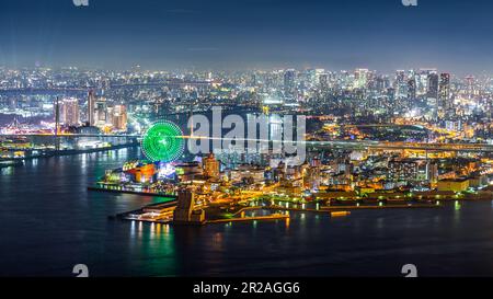 Kobe, Japan - 27. November 2018: Luftaufnahme des Hafens von Kobe mit hellem Licht auf Straßen und Gebäuden in der Nähe des Flusses bei Nacht. Stockfoto