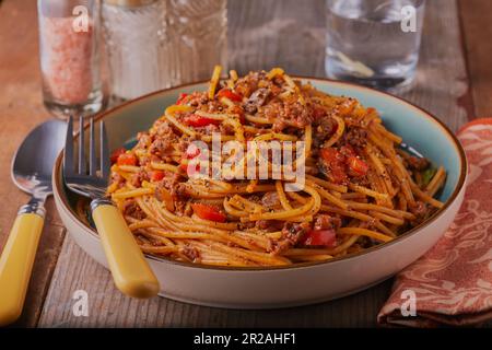 Teller mit Spaghetti Bolognese garniert mit Gewürzen und Kräutern. Stockfoto