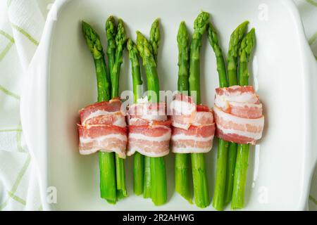 Grüner Spargel, gebacken mit Speck und Gewürzen. Sehr leckeres und gesundes Essen. Blick von oben Stockfoto