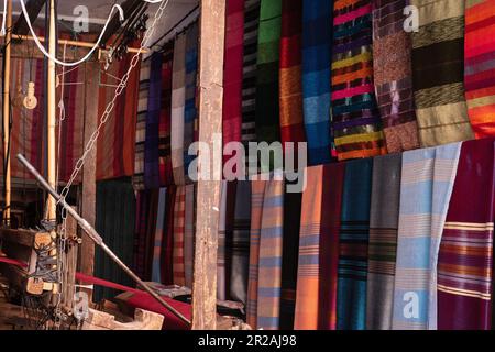 Einheimischer Handwerker, der traditionelle Rahmen nutzt und handgefertigte Textilien auf dem alten Kasbah-Markt kreiert. Marrakesch, Marokko Stockfoto