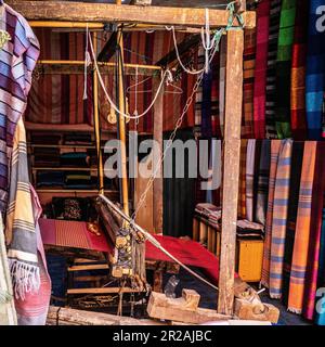 Einheimischer Handwerker, der traditionelle Rahmen nutzt und handgefertigte Textilien auf dem alten Kasbah-Markt kreiert. Marrakesch, Marokko Stockfoto