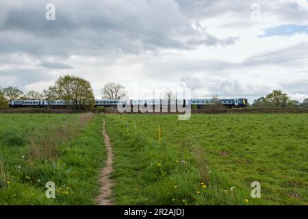 SWR-Zug fährt durch die Landschaft an einem stürmischen Frühlingstag Stockfoto