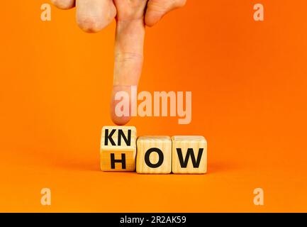 Know-how-Symbol. Geschäftsmann dreht Holzwürfel um und ändert das Wort "wie man es weiß". Schöner orangefarbener Tischhintergrund. Speicherplatz kopieren. Business und k Stockfoto