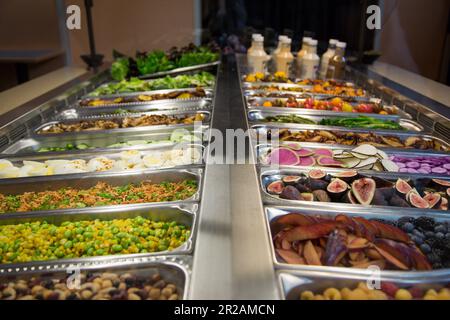 Essen und Salatbar mit einer großen Auswahl an Obst, Gemüse und Salatdressings Stockfoto