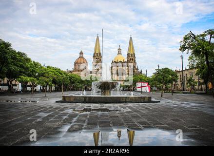 Guadalajaras Kathedrale an einem sonnigen, aber bewölkten Tag vom 'Plaza de la Liberacion' aus gesehen Stockfoto