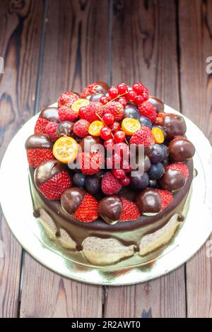 Reichhaltiger Schokoladen-Oreo-Kuchen mit Sauce und frischen Beeren, Erdbeere, Kirsche und Heidelbeere Stockfoto