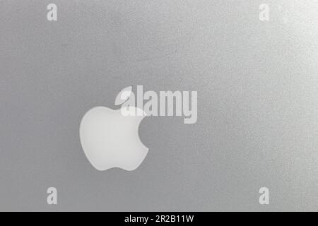 Sandgestrahlte Aluminiumstruktur mit Apfellogo auf dem macbook-Computer, silbergrauer Hintergrund. Stockfoto