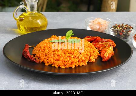 Traditioneller türkischer Bulgur-Pilaf mit Tomatensoße auf dem Teller (türkischer Name; Meyhane pilavi) Stockfoto