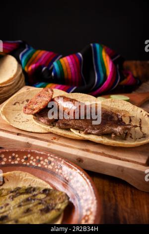 Im Taco-Campechano-Stil, Carne Asada. (Bratfleisch) und Chorizo oder Longaniza, sehr beliebtes Gericht in Nordmexiko, auch Asado, Discada oder Parrill genannt Stockfoto