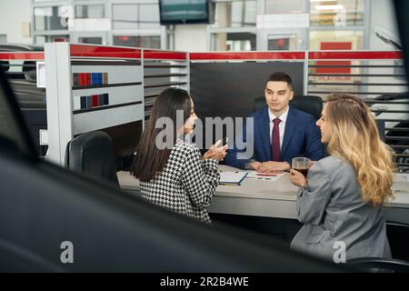 Zwei junge Frauen und ein Mann im Büro Stockfoto