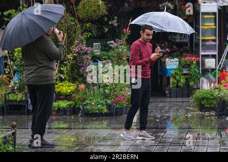 Istanbul, Türkei. 17. Mai 2023. Die Menschen hüten sich unter Sonnenschirmen entlang der EminÃ¶nÃ¼ während des Regenwetters. (Kreditbild: © Mine TOZ/SOPA Images via ZUMA Press Wire) NUR REDAKTIONELLE VERWENDUNG! Nicht für den kommerziellen GEBRAUCH! Stockfoto