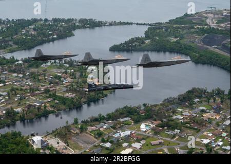 USA Air Force F-22 Raptors, die der 43D. Kampfgeschwader zugeteilt wurden, und ein T-38A Talon, die der 2D. Kampfgeschwader zugeteilt wurden, fliegen eine unterschiedliche Formation über dem Florida Panhandle, 10. April 2023. Die Formation war eine Hommage an die frühere Mission des 325. Fighter Wing, F-22 Raptor-Piloten fast 20 Jahre lang auszubilden. Der Flügel geht auf eine Kampfmission über, mit F-35A Lightning II Kampfflugzeuge, die in den nächsten Jahren ankommen. (USA Air Force Foto von Tech. Sgt. Betty R. Chevalier) Stockfoto