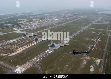 USA Air Force F-22 Raptors, die der 43D. Kampfgeschwader zugeteilt wurden, und ein T-38A Talon, die der 2D. Kampfgeschwader zugeteilt wurden, fliegen eine unterschiedliche Formation über dem Florida Panhandle, 10. April 2023. Die Formation war eine Hommage an die frühere Mission des 325. Fighter Wing, F-22 Raptor-Piloten fast 20 Jahre lang auszubilden. Der Flügel geht auf eine Kampfmission über, mit F-35A Lightning II Kampfflugzeuge, die in den nächsten Jahren ankommen. (USA Air Force Foto von Tech. Sgt. Betty R. Chevalier) Stockfoto