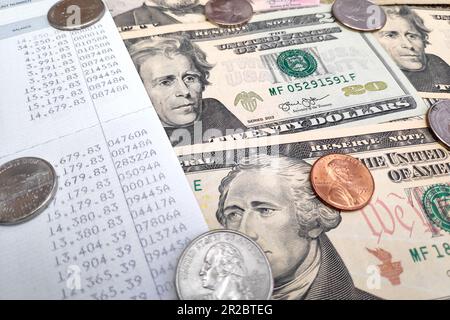 Nahaufnahme eines Sparbuchs mit einigen US-Münzen und US-Banknoten Dollar. Stockfoto