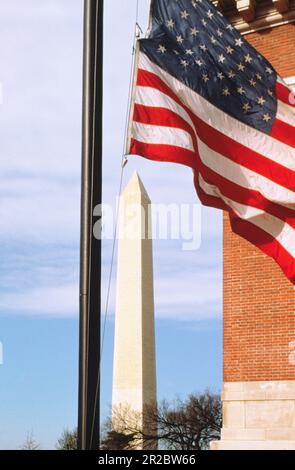 Washington Monument und amerikanische Flagge vor dem Holocaust Memorial Museum in der National Mall. Raoul Wallenberg Place in Washington DC USA Stockfoto