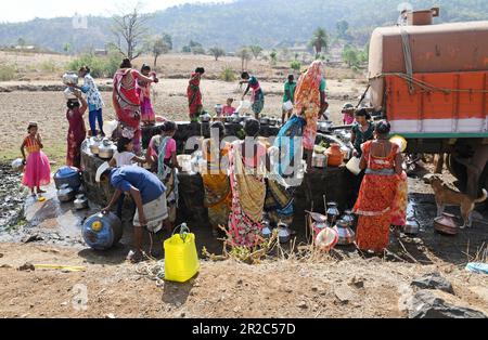 Mumbai, Indien. 16. Mai 2023. Dorfbewohner versammeln sich um einen Brunnen, um Wasser zu holen im Dorf Telamwadi bei Vihigaon, Shahapur-Taluka im Bezirk Thane bei Mumbai. Die Dorfbewohner sind während der Sommermonate mit akuter Wasserknappheit konfrontiert, da sie durch einen Wassertransporter, der nur einmal am Tag Wasser in den Brunnen entlädt, Wasser erhalten, was für sie und ihre Rinder für den täglichen Gebrauch nicht ausreicht. Kredit: SOPA Images Limited/Alamy Live News Stockfoto