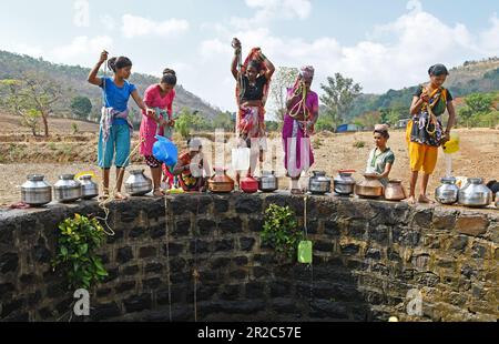 Mumbai, Indien. 16. Mai 2023. Die Dorfbewohner an der Grenzmauer ziehen Wasser aus dem Brunnen im Dorf Telamwadi in der Nähe von Vihigaon, Shahapur taluka des Bezirks Thane in der Nähe von Mumbai. Die Dorfbewohner sind während der Sommermonate mit akuter Wasserknappheit konfrontiert, da sie durch einen Wassertransporter, der nur einmal am Tag Wasser in den Brunnen entlädt, Wasser erhalten, was für sie und ihre Rinder für den täglichen Gebrauch nicht ausreicht. Kredit: SOPA Images Limited/Alamy Live News Stockfoto