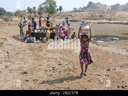 Mumbai, Indien. 16. Mai 2023. Ein junges Mädchen trägt einen Topf Wasser, nachdem es ihn aus dem Brunnen auf dem Kopf gefüllt hat, während sie nach Hause geht in Telamwadi Dorf in der Nähe von Vihigaon, Shahapur Taluka von Thane Distrikt in der Nähe von Mumbai. Die Dorfbewohner sind während der Sommermonate mit akuter Wasserknappheit konfrontiert, da sie durch einen Wassertransporter, der nur einmal am Tag Wasser in den Brunnen entlädt, Wasser erhalten, was für sie und ihre Rinder für den täglichen Gebrauch nicht ausreicht. Kredit: SOPA Images Limited/Alamy Live News Stockfoto