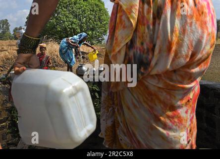 Mumbai, Maharashtra, Indien. 16. Mai 2023. Eine Frau, die Wasser in das Gefäß gießt, nachdem sie es aus dem Brunnen im Dorf Telamwadi in der Nähe von Vihigaon, Shahapur Taluka im Bezirk Thane in der Nähe von Mumbai gezogen hat. Die Dorfbewohner sind während der Sommermonate mit akuter Wasserknappheit konfrontiert, da sie durch einen Wassertransporter, der nur einmal am Tag Wasser in den Brunnen entlädt, Wasser erhalten, was für sie und ihre Rinder für den täglichen Gebrauch nicht ausreicht. (Kreditbild: © Ashish Vaishnav/SOPA Images via ZUMA Press Wire) NUR REDAKTIONELLE VERWENDUNG! Nicht für den kommerziellen GEBRAUCH! Stockfoto