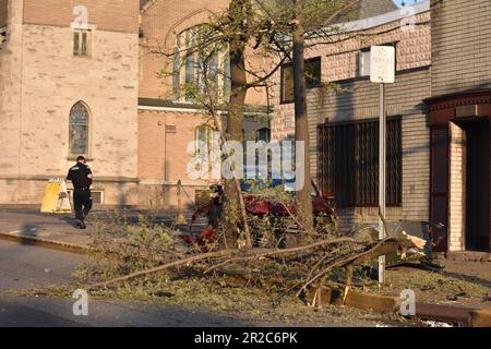 Paterson, Usa. 18. Mai 2023. Ein einzelnes Fahrzeug stößt gegen einen Baum und einen Briefkasten und hinterlässt mehrere Zweige, schwere Schäden und Verunreinigungen auf den Bürgersteigen und auf der Straße. Ein einzelnes Fahrzeug stürzte gegen einen Baum und einen Briefkasten, sodass eine Person eine Herz-Lungen-Wiederbelebung erhalten musste. Zu diesem Zeitpunkt ist nicht bekannt, in welchem Zustand sich die Person befindet. Der Tatort wurde mit Tatortband festgehalten. Die Polizei von Paterson bewachte das Gebiet, um die Beweise zu bewahren. Der Unfall ereignete sich gegen 7:00 Uhr Eastern Time, Donnerstagabend. Kredit: SOPA Images Limited/Alamy Live News Stockfoto