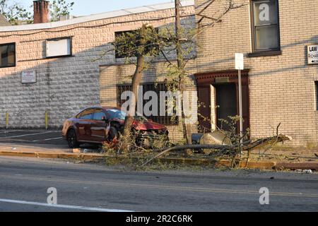 Paterson, Usa. 18. Mai 2023. Ein einzelnes Fahrzeug stößt gegen einen Baum und einen Briefkasten und hinterlässt mehrere Zweige, schwere Schäden und Verunreinigungen auf den Bürgersteigen und auf der Straße. Ein einzelnes Fahrzeug stürzte gegen einen Baum und einen Briefkasten, sodass eine Person eine Herz-Lungen-Wiederbelebung erhalten musste. Zu diesem Zeitpunkt ist nicht bekannt, in welchem Zustand sich die Person befindet. Der Tatort wurde mit Tatortband festgehalten. Die Polizei von Paterson bewachte das Gebiet, um die Beweise zu bewahren. Der Unfall ereignete sich gegen 7:00 Uhr Eastern Time, Donnerstagabend. Kredit: SOPA Images Limited/Alamy Live News Stockfoto