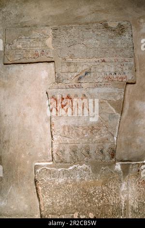 Alte ägyptische Farbbilder an der Wand im Grab. Große Schrittpyramide von Djoser, Sakkara. Kairo, Ägypten. Das Grab der Pharaonen. Altes ägyptisches Schreiben Stockfoto