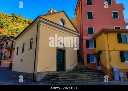 Die Oratoriumskapelle der Santissima Annunziata oder degli Azzurri und die traditionellen bunten Häuser in Manarola, Cinque Terre, Italien Stockfoto