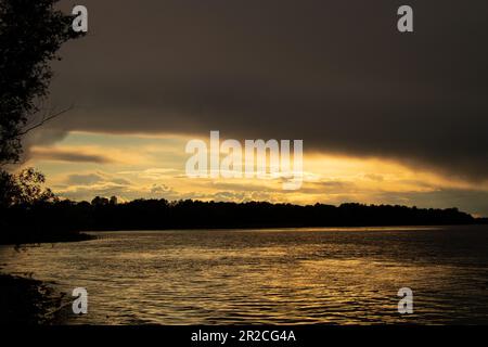 Gewitterwolken bei Sonnenuntergang über dem Dnieper River Stockfoto