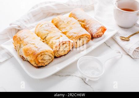 Hausgemachter Apfelstrudel mit Zimt, Apfelkuchen mit einer Tasse Obsttee Stockfoto