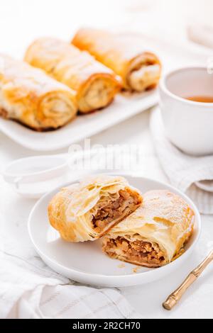 Hausgemachter Apfelstrudel mit Zimt, Apfelkuchen mit einer Tasse Obsttee Stockfoto