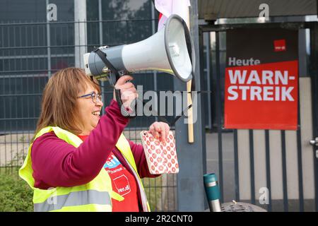 Hamburg, Deutschland. 19. Mai 2023. Ein Teilnehmer spricht während einer Rallye im Rahmen eines Warnstreiks vor dem H&M Logistikzentrum in Hamburg-Allermöhe mit Mitarbeitern. Im Lohnstreit um 90.000 Beschäftigte im Hamburger Einzelhandel und Versandhandel hat die Gewerkschaft Verdi den ersten Warnstreik in der Hansestadt am Freitag und Samstag gefordert. Kredit: Bodo Marks/dpa/Alamy Live News Stockfoto