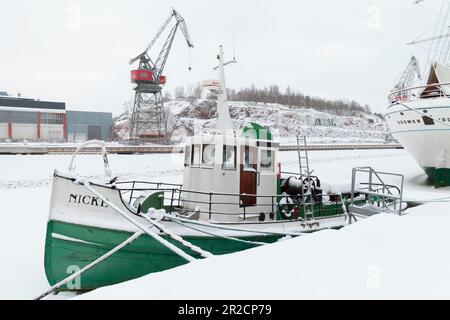 Turku, Finnland - 17. Januar 2016: An einem Wintertag liegt ein kleines Boot an der Küste des Flusses Aura vor. Blick auf den Hafen von Turku Stockfoto