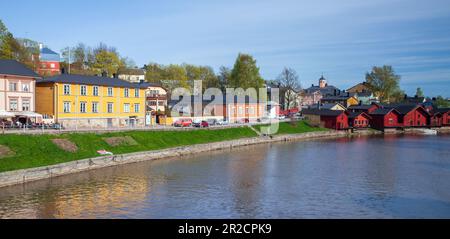 Porvoo, Finnland - 7. Mai 2016: Panoramafoto der Stadt Porvoo mit roten Holzhäusern entlang der Flussküste, normale Menschen laufen Stockfoto