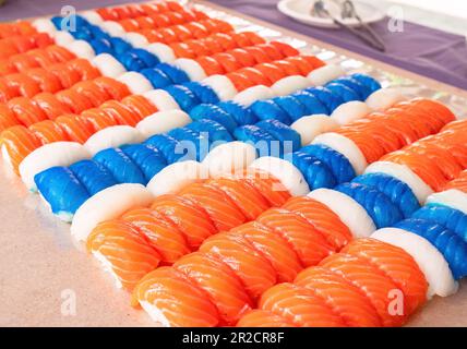 Nigiri-Sushi-Stücke, 140 Stück, aus Lachs, weißem Fisch und blauem weißem Fisch, der wie eine norwegische Flagge aussieht. Geringe Tiefe von f Stockfoto