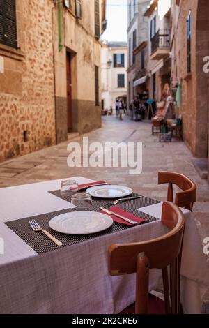 Tisch im Restaurant auf der Straße in Alcudia, Mallorca. Traditionelle Altstadt in Spanien Stockfoto