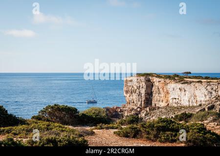 Klippe auf Mallorca mit schwimmendem Boot auf dem Meer. Wunderschöne Küste der Balearen Stockfoto